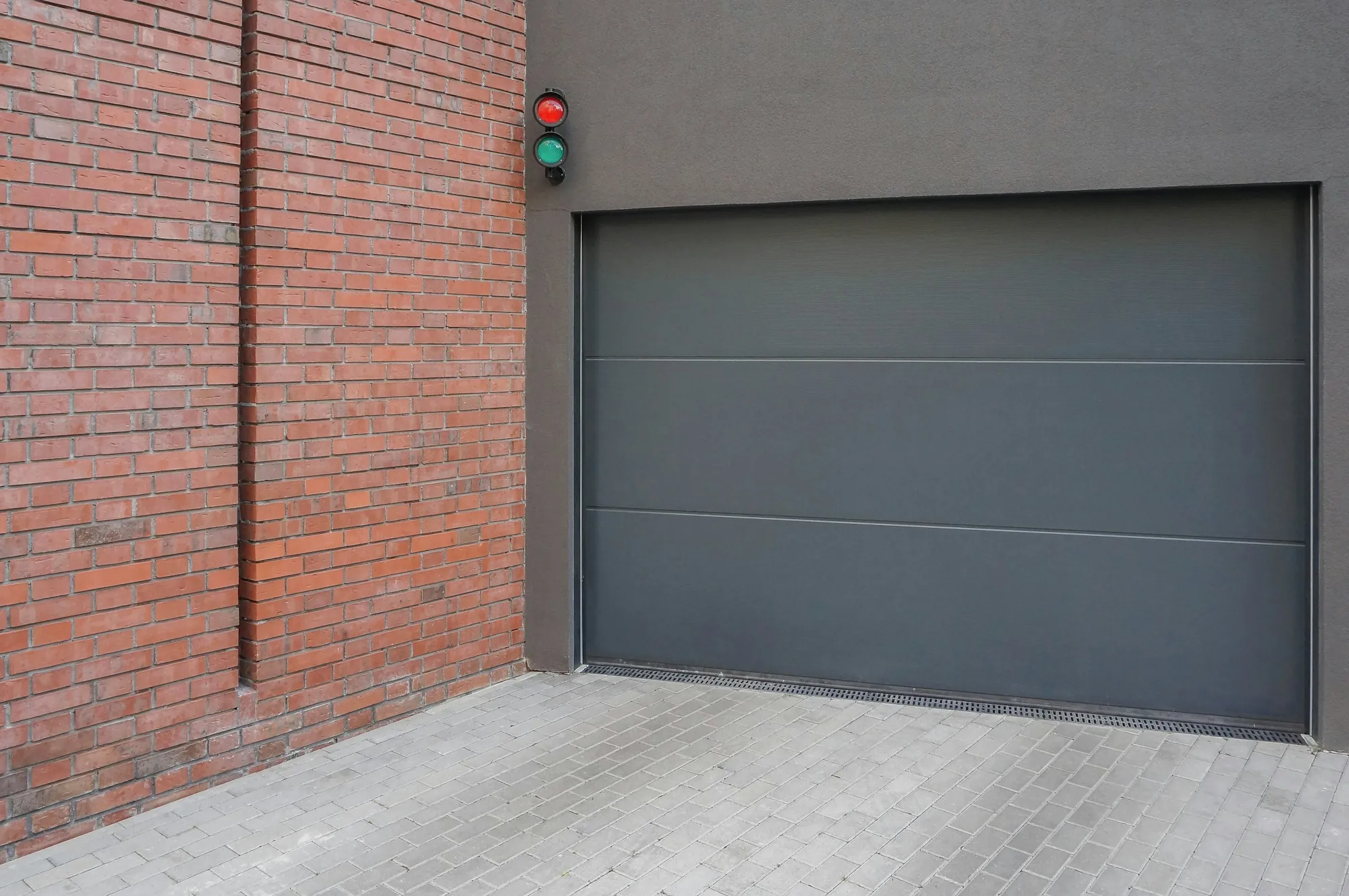 Dark gray garage door set into a brick wall