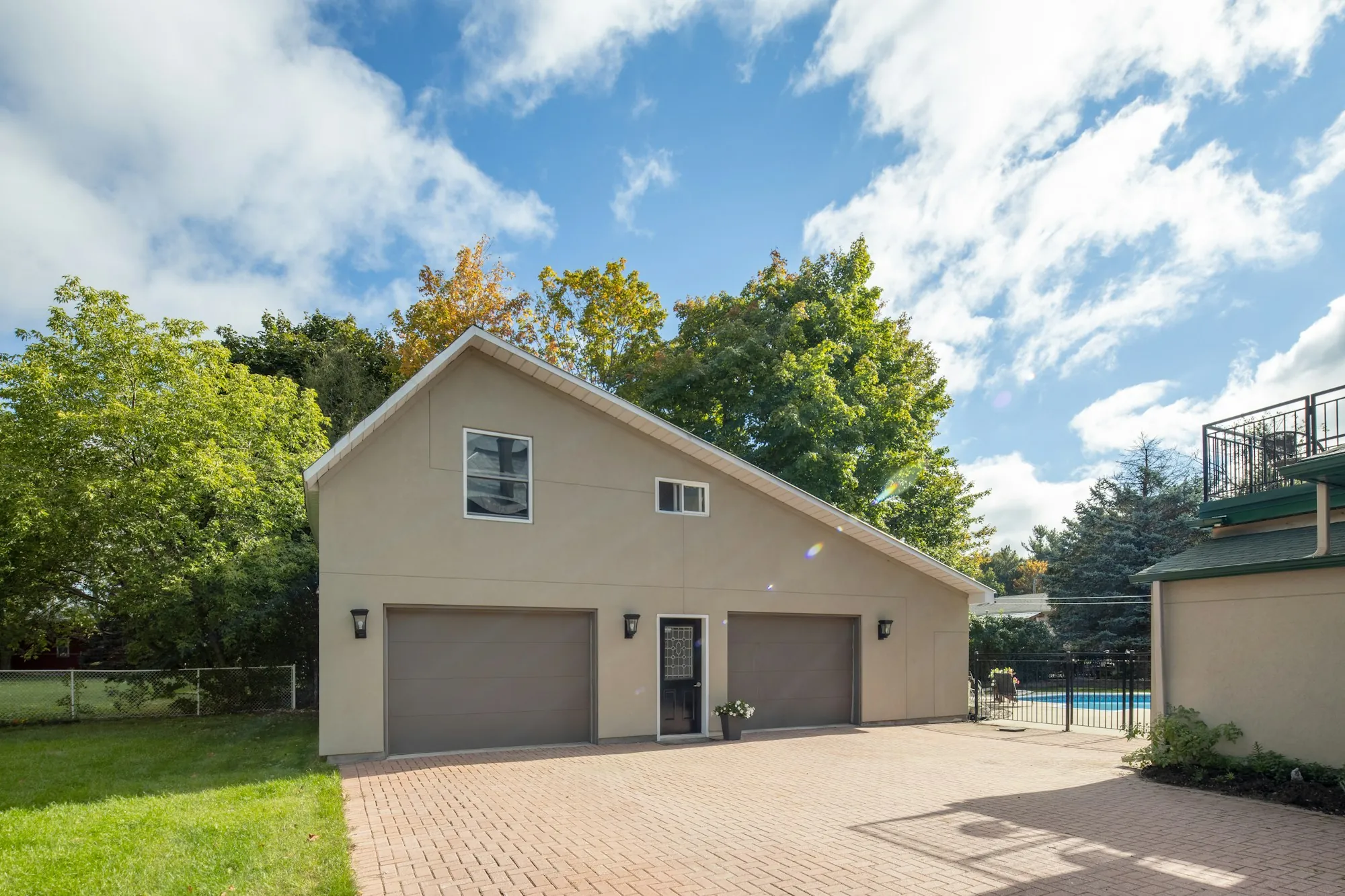 Beige house with two garage doors and a paved driveway